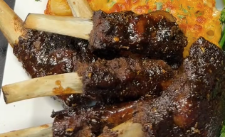 Sticky lamsspareribs met glanzende saus, geserveerd met bijgerechten