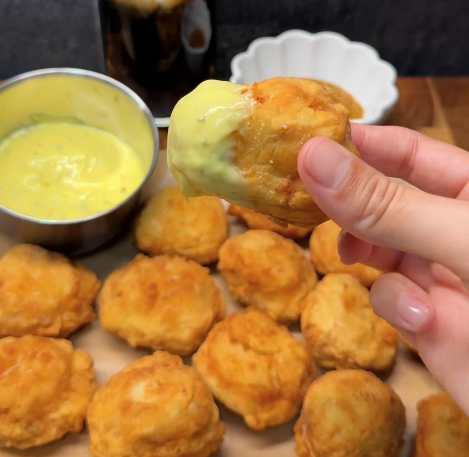 Zelfgemaakte krokante kipnuggets gefrituurd en geserveerd met zoetzure saus en fritessaus