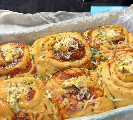 Fluffy kaas knoflook rolls bestrooid met kruidenboter, mozzarella en verse peterselie vers uit de oven